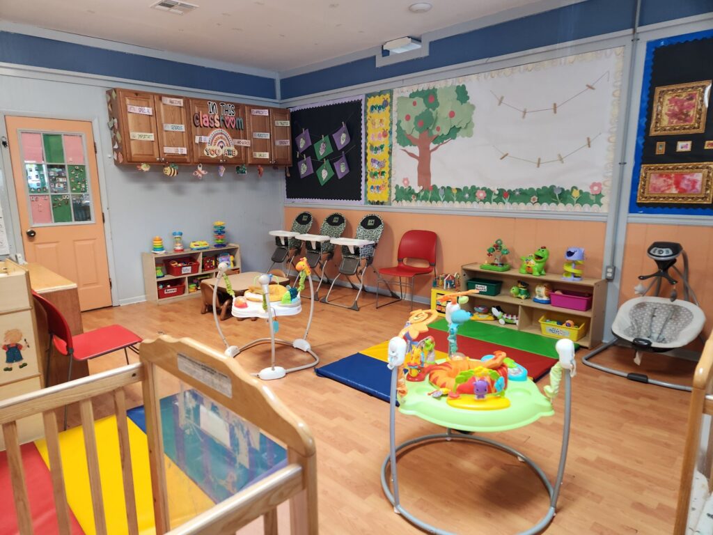 The Baby Room at The Art Learning Center, with cribs, play mats and toys
