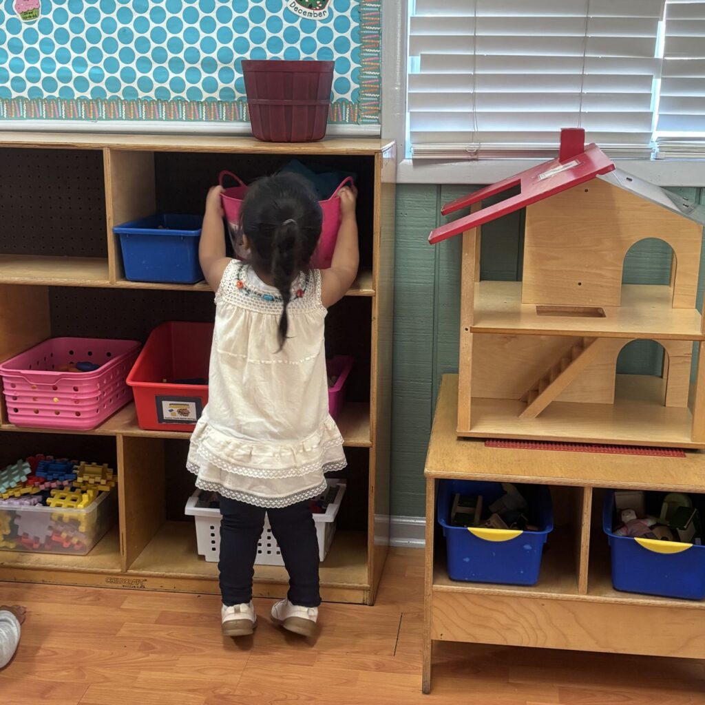 Child choosing materials from a classroom shelf
