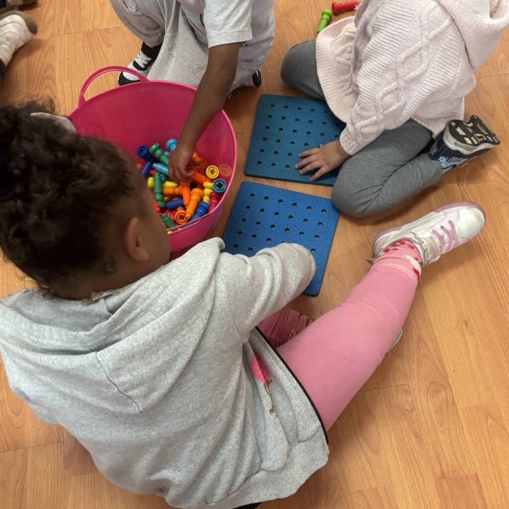 Children building together with linking toys
