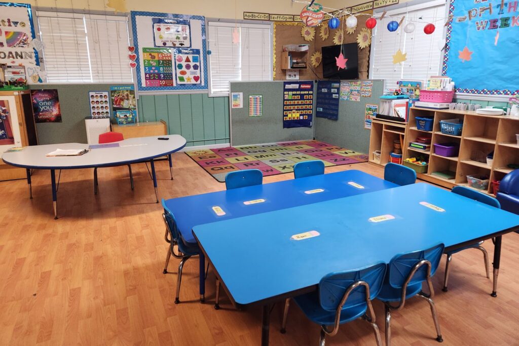 Preschool classroom with learning centers, tables and wall displays