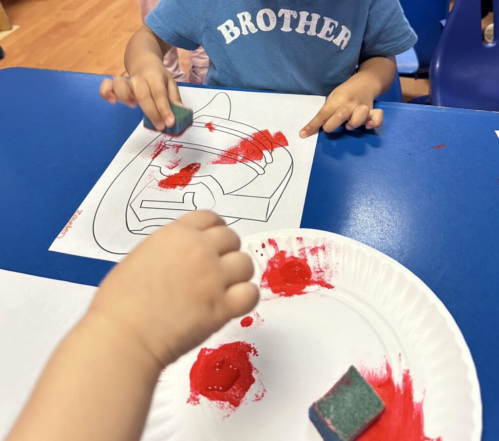 Children sponge painting fire hats during Fire Safety Week