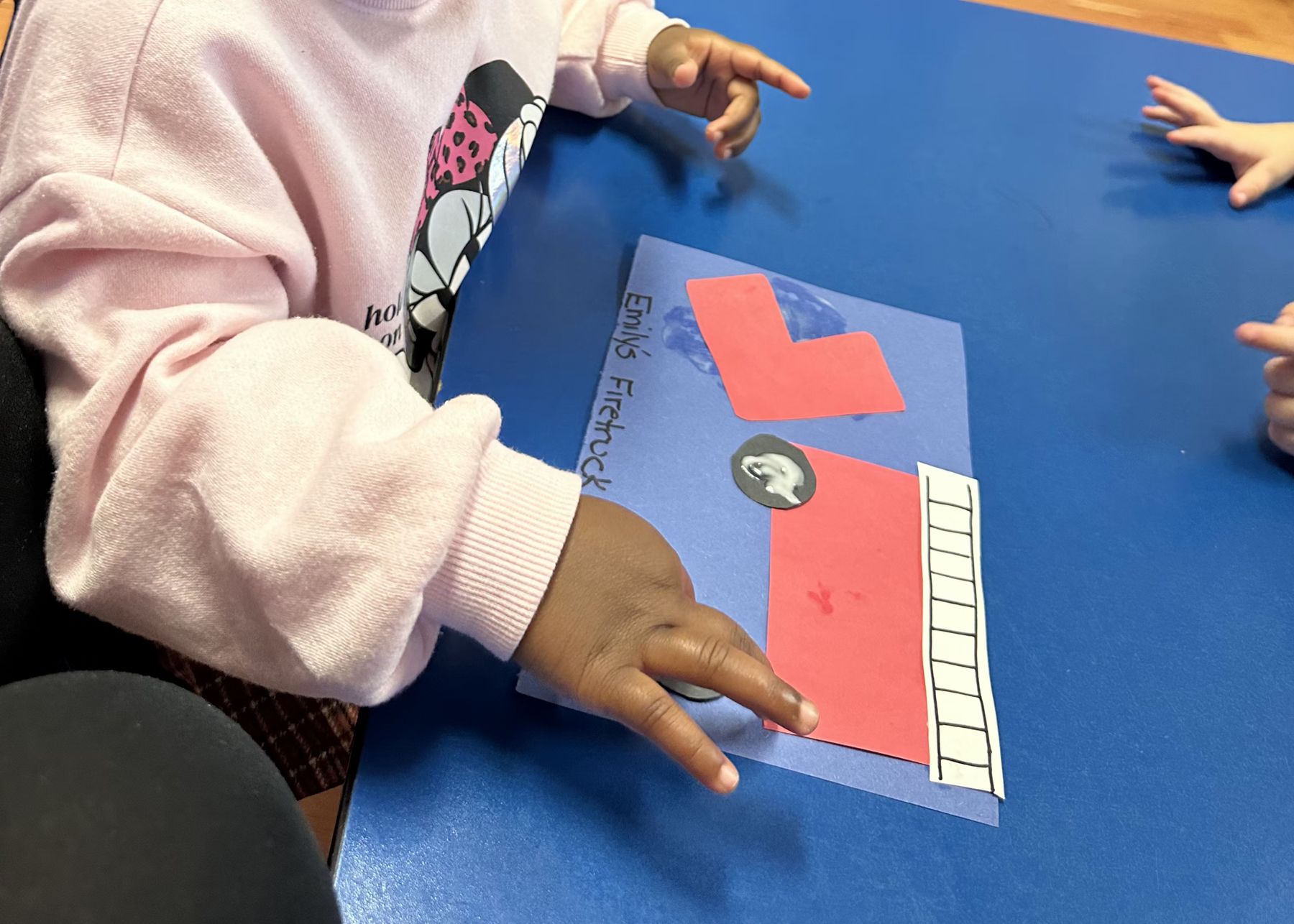Child assembling a paper firetruck